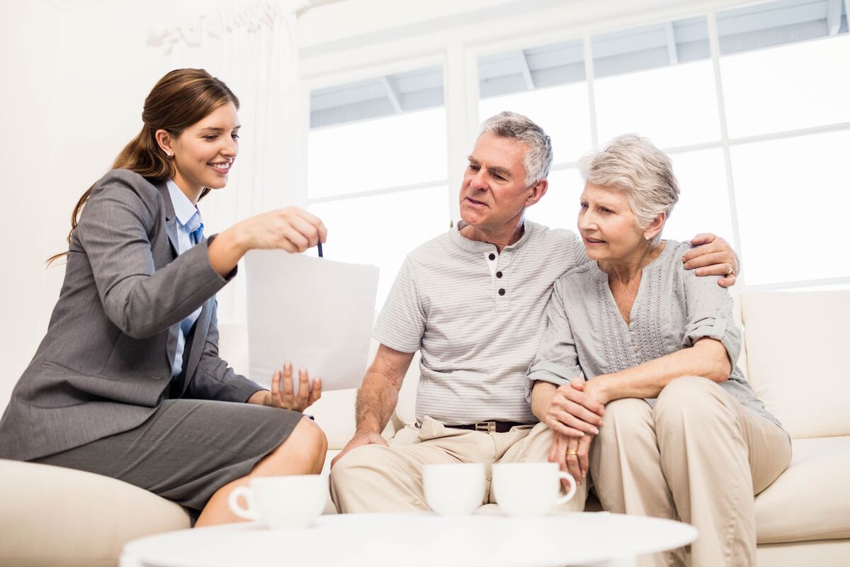 Professional conducting an in-home document review with a senior couple