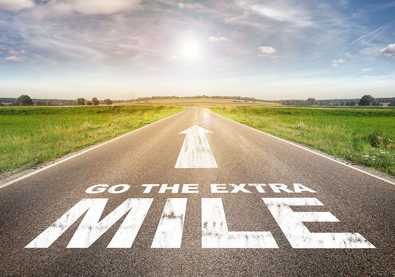 Picture of the open road with the text Go the extra mile written across it