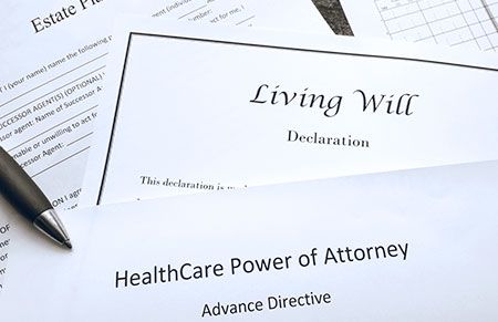 stack of documents labeled Living will, HealthCare Power of Attorney, and Estate Planning
