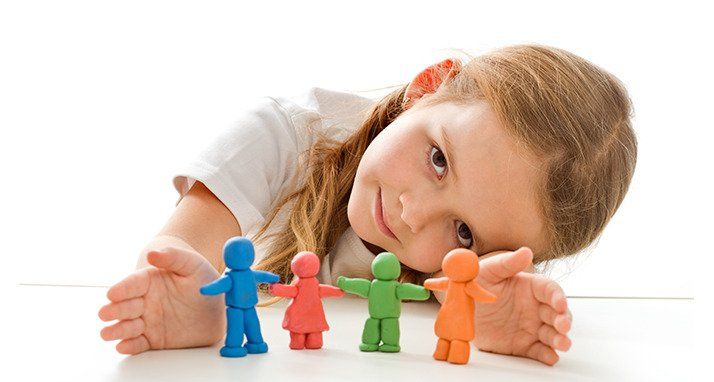 a child presenting four dolls made our of play dough