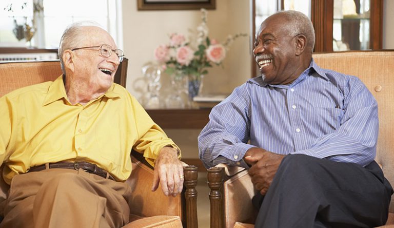 Two older men sitting together and laughing