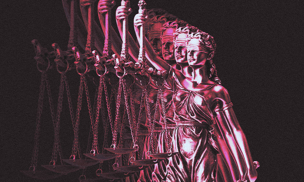A series of metallic statues of Lady Justice, each holding scales and a sword, are aligned in a row