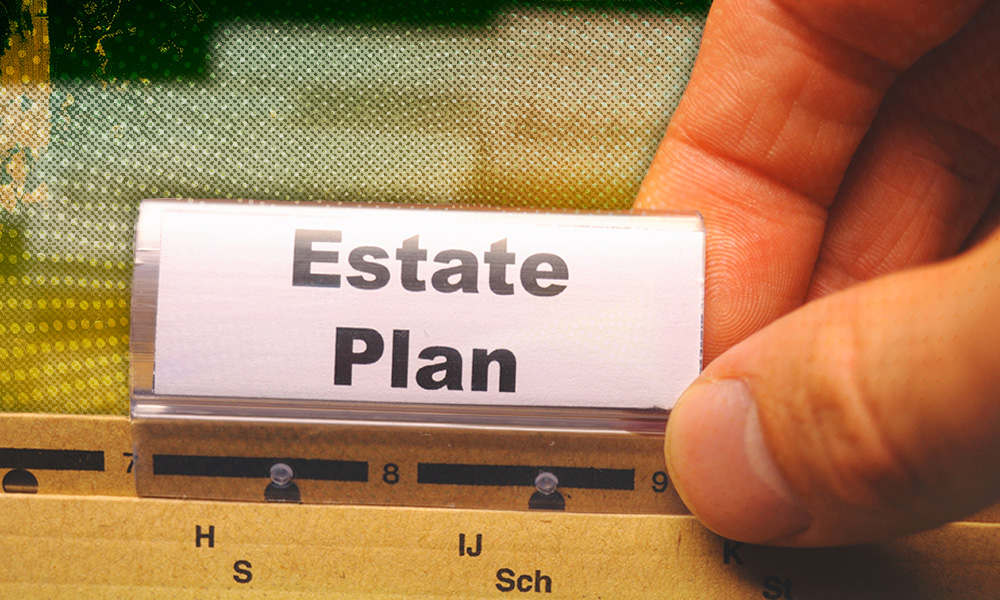 A hand selecting a file labeled 'Estate Plan' from a folder, symbolizing the need to review estate planning documents during key life events.