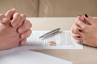 Man and woman signing divorce document
