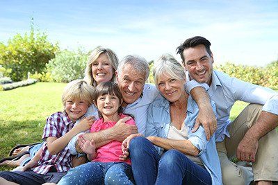 a multi-generational family sitting together hugging and smiling