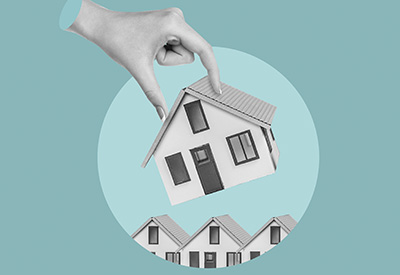 A hand removing a house from a row of homes, illustrating the risk of losing home ownership or assets due to inadequate estate planning or improper deed transfer.