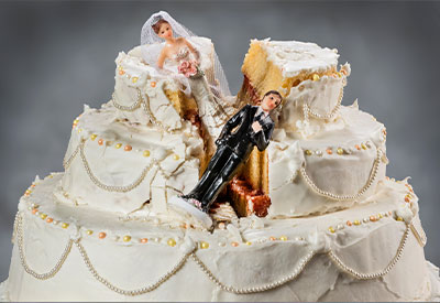 A wedding cake with white frosting and decorative pearls is split down the middle like a tale of untended estate planning