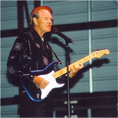 Glen Campbell playing guitar and singing on stage