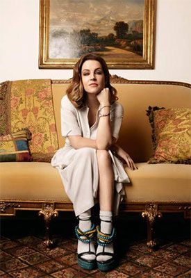 Lisa Marie Presley siting on a couch posing for a picture