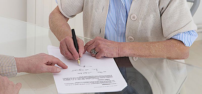 a woman signing an estate planning document