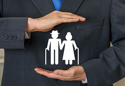 A person in a suit shielding a symbol of elderly individuals, representing the importance of protecting senior rights and addressing guardianship abuse.