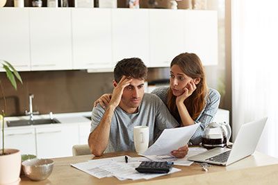 Estate Plan - Middle aged couple sitting at a table worried while reviewing documents