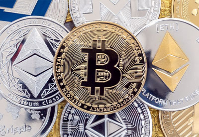 A collection of various cryptocurrency coins, including Bitcoin in the center, surrounded by Ethereum, Ripple, and others
