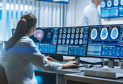 A medical professional in a lab coat sits at a desk, reviewing brain scans and discussing an advance directive