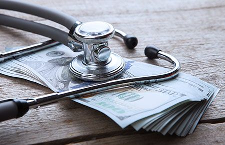 a stethoscope sitting ontop a pile of cash
