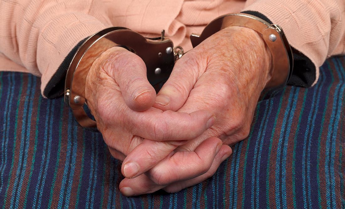 A senior handcuffed