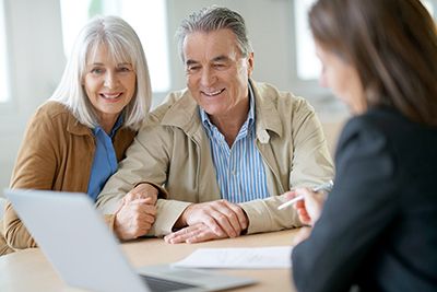 a senior couple reviewing documents with an estate planning attorney 
