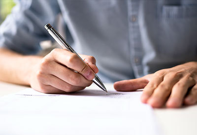 person writing on piece of paper