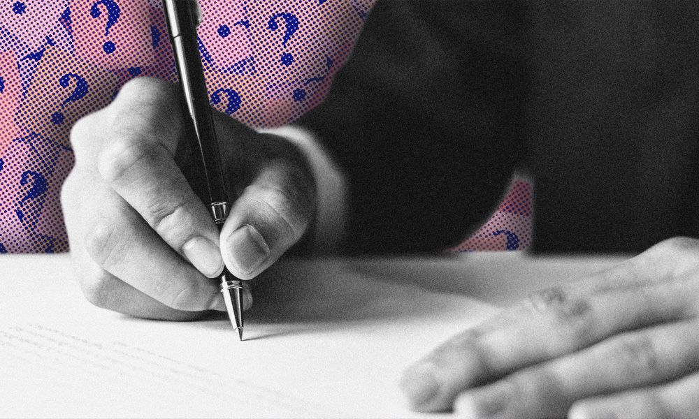 A person in a business suit, perhaps a successor trustee, is meticulously writing on paper with a pen