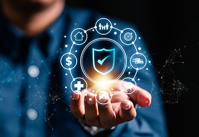 A glowing shield surrounded by icons representing family, assets, and health care