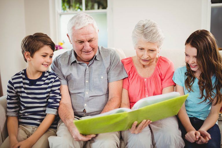 a senior couples showing pictures to the grandkids