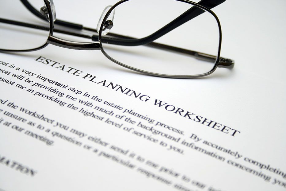 a pair of glasses resting ontop of a estate planning worksheet document