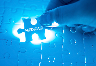 A glowing puzzle piece labeled 'Medicaid' being placed into a puzzle