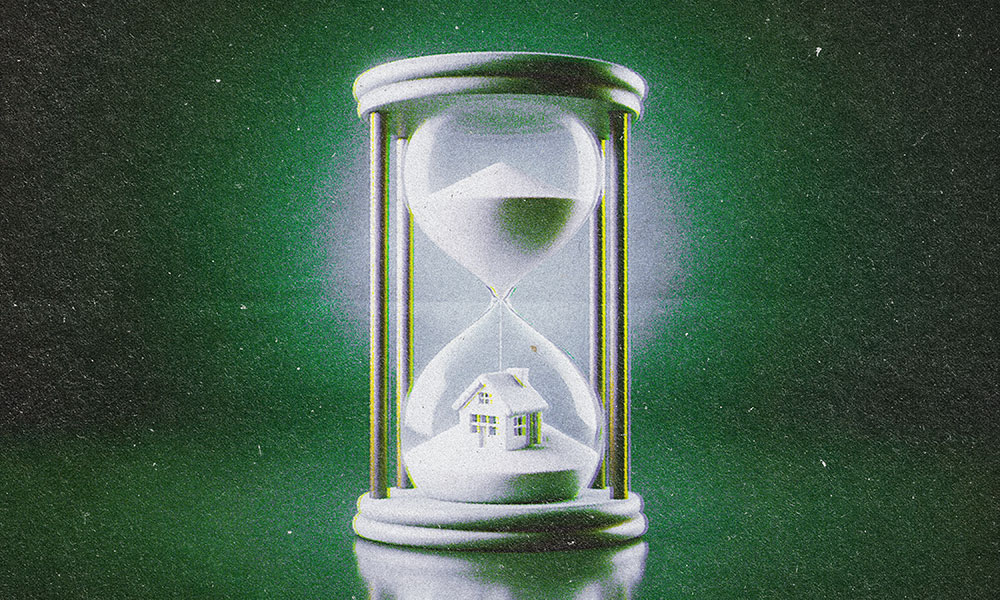 A green-tinted image of an hourglass filled with sand. The top chamber is full, and the bottom features a small model house partially buried