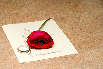 In rememberance card with a rose and ring on top of it