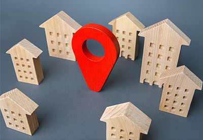 wooden block building in a circle with a wooden map pin in the middle
