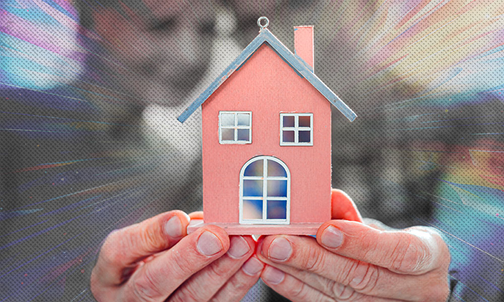 A pair of hands holding a small model house with a glowing, dynamic background
