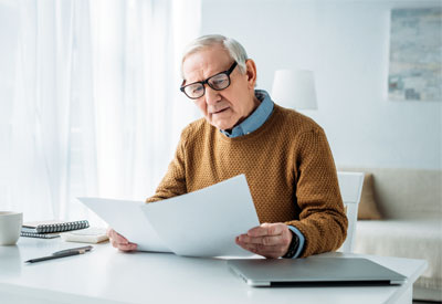 Senior reviewing estate plan documents, focusing on testamentary capacity, legal challenges, and the importance of wills, trusts, and medical records.