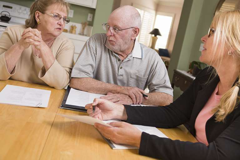 Professional helping a senior couple with their estate plan