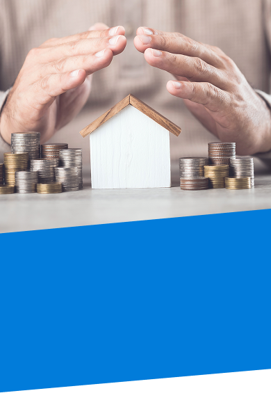 a pair of hands covering a model home and stacked coins on a table