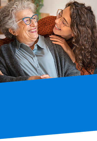 elderly woman and her adult daughter hugger her from behind